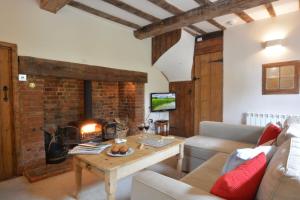 a living room with a couch and a fireplace at 1 Tunns Cottages, Rushmere, nr Beccles in Beccles