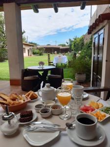 een tafel met ontbijtproducten en drankjes erop bij Casa del Sol Cafayate in Cafayate