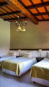 sypialnia z 2 łóżkami i żyrandolem w obiekcie Casa del Sol Cafayate w mieście Cafayate