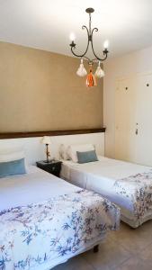 a bedroom with two beds and a chandelier at Casa del Sol Cafayate in Cafayate