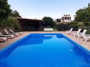 a blue swimming pool with chairs at Casa del Sol Cafayate in Cafayate