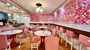 een restaurant met tafels en stoelen en roze bloemen bij La Choeben Suites in Calbayog