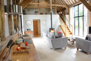 a living room with couches and a fireplace at Manor House Barn, Peasenhall in Peasenhall