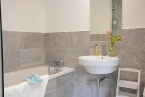 a bathroom with a sink and a bath tub at 2 Pink Cottages, Aldeburgh in Aldeburgh