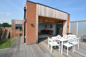 a patio with a table and chairs on a deck at Skylight, Aldeburgh in Aldeburgh