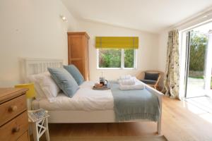 a bedroom with a bed with a tray of food on it at 2 Pink Cottages, Aldeburgh in Aldeburgh