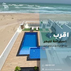 an aerial view of a house on the beach at bh villa in Al Ashkharah