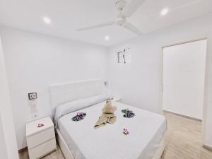 biała sypialnia z białym łóżkiem z kwiatami w obiekcie Luxury San Marino apartment & pool view w mieście Los Cristianos +20 zdjęć