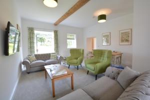 a living room with a couch and chairs and a table at Ploughman's Green, Blythview in Blythburgh