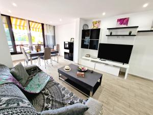 salon z kanapą i telewizorem z płaskim ekranem w obiekcie Luxury San Marino apartment & pool view w mieście Los Cristianos