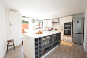 a kitchen with white cabinets and a kitchen island at Pine Cottage in Woodbridge