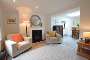 a living room with two chairs and a fireplace at Pine Cottage in Woodbridge