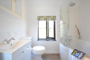 ein Badezimmer mit Waschbecken und Toilette und einem Fenster in der Unterkunft Pine Cottage in Woodbridge + 12 Fotos