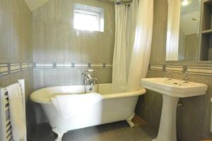 a bathroom with a bath tub and a sink at Robert Sadler's Studio in Aldeburgh +14 photos