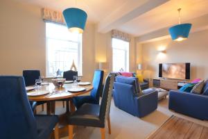 a dining room with a table and blue chairs at Skimming Stones, Aldeburgh in Aldeburgh