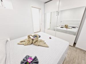 Pokój z łóżkiem z ręcznikami i lustrem w obiekcie Luxury San Marino apartment & pool view w mieście Los Cristianos