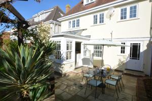 a patio with a table and chairs and a white house at Neptune in Aldeburgh