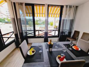jadalnia ze stołem i butelką wina w obiekcie Luxury San Marino apartment & pool view w mieście Los Cristianos