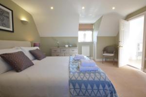 a large bedroom with a large bed with blue pillows at Neptune in Aldeburgh