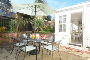 a table and chairs with an umbrella on a patio at Neptune in Aldeburgh
