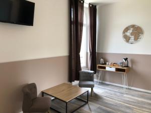 a living room with a table and a chair at CHAMBRES D'HOTES DANS DOMAINE DE CHARME A EPERNAY in Mardeuil