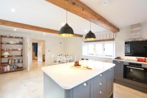 a kitchen with a white counter top and a kitchen island at Woodland Cottage, Great Glemham in Framlingham