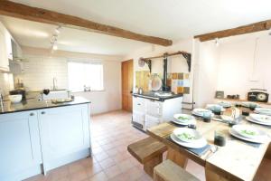 a kitchen with a table with plates on it at The White House with Studio in Homersfield