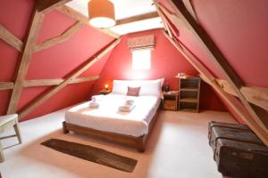 a bedroom with a bed in a attic with red walls at The White House with Studio in Homersfield