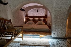 - une chambre avec un lit dans une pièce en pierre dans l'établissement Sklep jinak, à Jihlava