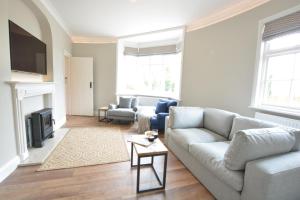 a living room with a couch and a tv at The Round House in Kettleburgh