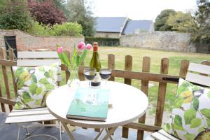 a table with two glasses of wine and a book at Church Farm Cottage, Dunwich in Westleton