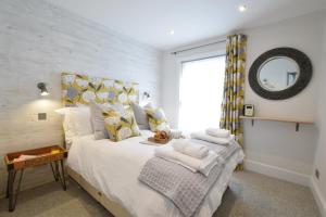 ein Schlafzimmer mit einem großen Bett mit Spiegel in der Unterkunft 53 Tern Cottage, Aldeburgh in Aldeburgh