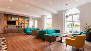 sala de estar con sillas verdes y sofá en Holiday Inn Darlington-A1 Scotch Corner, an IHG Hotel en Scotch Corner