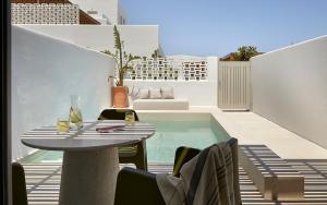 a patio with a table and chairs and a swimming pool at PAROCKS Luxury Hotel & Spa in Ambelas