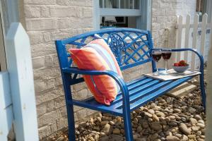 um banco azul com almofadas e um copo de vinho em Smugglers Rest, Aldeburgh em Aldeburgh