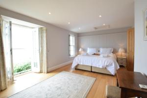 a bedroom with a white bed and a large window at Cannons in Southwold
