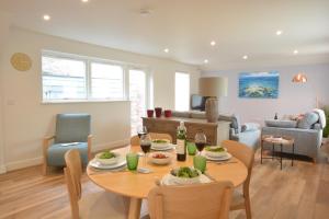 a dining room and living room with a table and chairs at Bramertons Nest, Long Melford in Long Melford