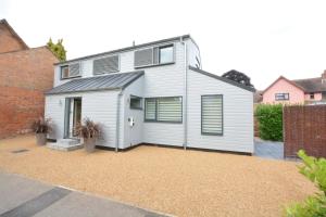 a white house with a garage at Bramertons Nest, Long Melford in Long Melford