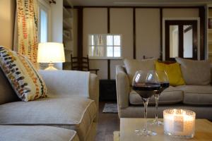 a living room with a glass of wine on a table at Corner Cottage, Dennington in Framlingham