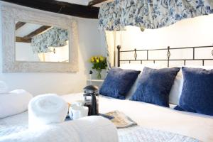 a bedroom with a bed with blue and white pillows at The Moorings, Orford in Orford