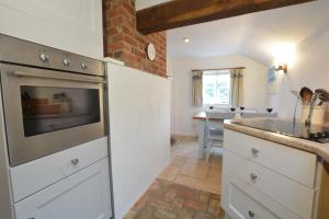 a kitchen with a sink and a stove top oven at The Moorings, Orford in Orford