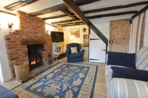 a living room with a brick fireplace and a couch at The Moorings, Orford in Orford