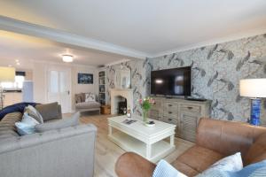 uma sala de estar com um sofá e uma televisão em Napier House, Southwold em Southwold