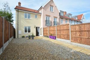 a backyard with a fence and a house at Lapwings, Aldeburgh in Aldeburgh