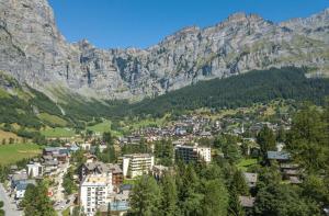 a city in the mountains with trees and buildings at Tarbey Alpine Apartment Leukerbad in Leukerbad