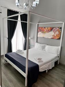1 dormitorio con cama con dosel y ventana en Duca di Uzeda Bed & Breakfast Luxury and Style, en Catania