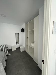 a white room with a bed and a mirror at El Gallinero in Almoharín +65 photos