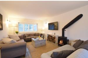 a living room with a couch and a fireplace at Blackshore House, Wenhaston in Southwold