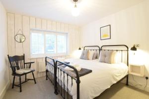 um quarto com uma cama e uma cadeira em Blackshore House, Wenhaston em Southwold