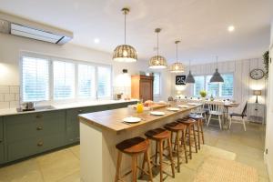 una gran cocina con una larga isla con taburetes de bar en Blackshore House, Wenhaston, en Southwold